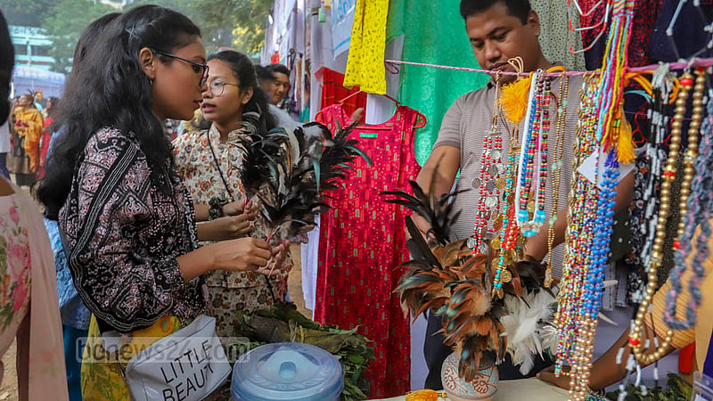 ঢাকার বনানী বিদ্যানিকেতনে শুক্রবার ওয়ানগালা উৎসবে এক স্টল থেকে দমি (পালকের তৈরি) কিনছেন গারো তরুণীরা। এটি তাদের ঐতিহ্যবাহী পোশাকের অংশ। ছবি: আসিফ মাহমুদ অভি