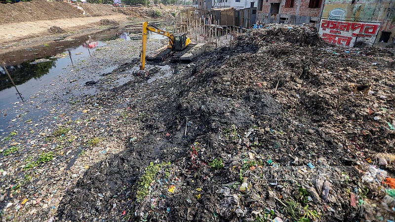 বুড়িগঙ্গা নদীর আদি চ্যানেল উদ্ধারে বৃহস্পতিবার লালবাগ সেকশন বেড়িবাঁধ থেকে কামরাঙ্গীরচরে প্রবেশের অংশ ভরাট হয়ে ছিল বর্জ্যে। স্কেভেটর দিয়ে চ্যানেল থেকে দীর্ঘদিনের জমে থাকা আবর্জনা তোলা হচ্ছে।