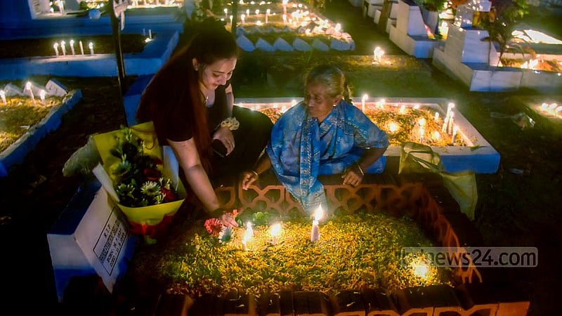 ‘অল সোলস ডে’তে বুধবার চট্টগ্রামে সমাধিস্থলে মোমবাতি জ্বালিয়ে মৃতের আত্মার শান্তি কামনায় শিশুসহ এক খ্রিস্টান পরিবার।