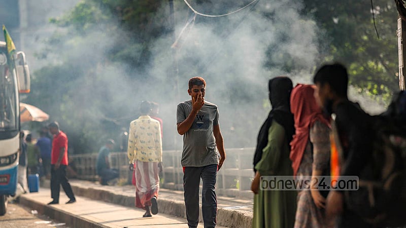 রামপুরা ব্রিজের উপর নাক আর মুখ হাত দিয়ে চেপে ধরে ময়লা-আবর্জনা পোড়া ধোঁয়ার মধ্য দিয়ে হেঁটে যাচ্ছেন এক ব্যক্তি ।
