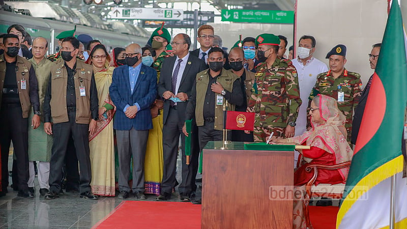 ঢাকার উত্তরায় দিয়াবাড়ি স্টেশনে সবুজ পতাকা দুলিয়ে মেট্রো ট্রেন চলাচলের সবুজ সংকেত দেন প্রধানমন্ত্রী, ট্রেনে ওঠার আগে সেই পতাকায় সইও করেন তিনি।&amp;nbsp;ছবি: মোস্তাফিজুর রহমান
