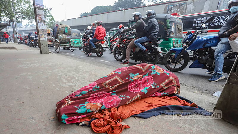 কনকনে শীত এখন সারাদেশে; ঢাকায়ও উঁকি দিচ্ছে না সূর্য, বিপাকে ছিন্নমূল মানুষরা। এমনই একজনকে বুধবার তেজগাঁও এলাকায় সড়কের পাশে ঘুমাতে দেখা যায়। শীত থেকে বাঁচতে চাদর মুড়ি দিয়েছিলেন তিনি। ছবি: আসিফ মাহমুদ অভি