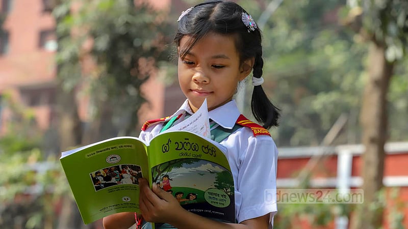 বই উৎসবে মাতৃভাষায় নতুন পাঠ্যবই পেয়ে চোখ বুলিয়ে নিচ্ছে এক চাকমা শিশু। ছবি: আসিফ মাহমুদ অভি