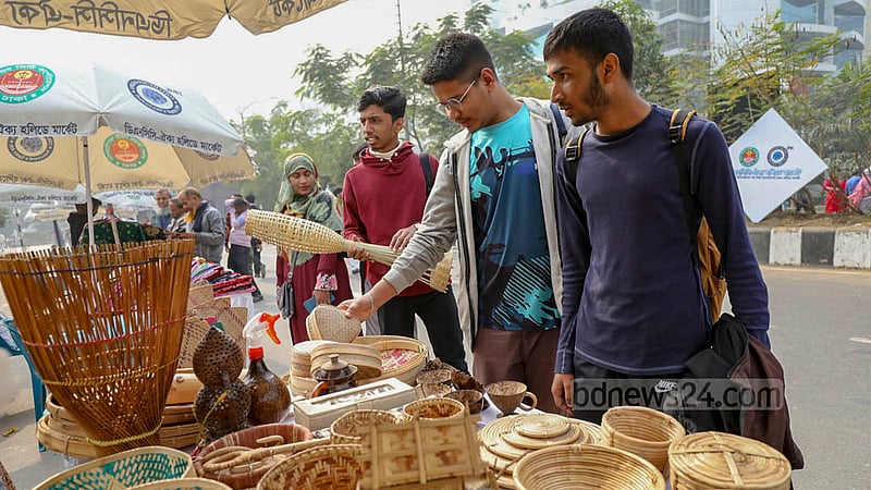আগারগাঁওয়ের আইসিটি সড়কের উপর হলিডে মার্কেটের বিভিন্ন স্টল ঘুরে দেখেন ক্রেতারা।