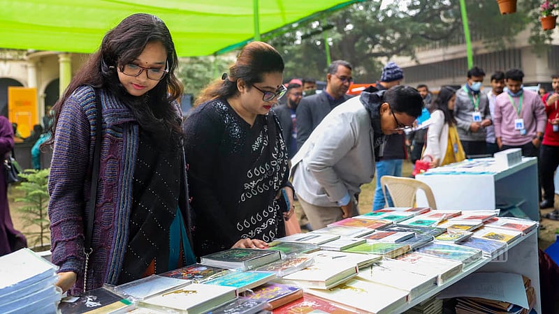 বৃহস্পতিবার ঢাকা লিট ফেস্টের প্রথম দিনে বাংলা একাডেমি প্রাঙ্গণে একটি স্টলে বই দেখছেন দুই নারী।&amp;nbsp;ছবি: মাহমুদ জামান অভি