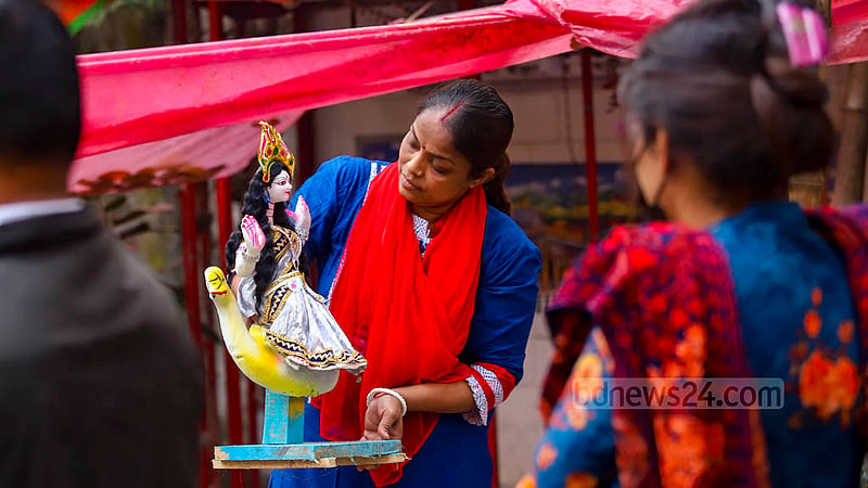 পুরান ঢাকার শাঁখারি বাজারে সরস্বতীর প্রতিমা দেখছেন ক্রেতারা।&amp;nbsp;ছবি: মাহমুদ জামান অভি