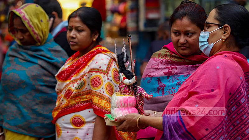 পুরান ঢাকার শাঁখারি বাজারে বিদ্যার দেবী সরস্বতীর প্রতিমা দেখছেন নারী ক্রেতারা।&amp;nbsp;ছবি: মাহমুদ জামান অভি