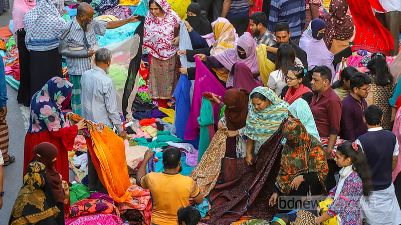 ঢাকার মতিঝিল আইডিয়াল স্কুল অ্যান্ড কলেজের সামনে শুক্রবার ‘হলিডে মার্কেটে’ পোশাক দেখছেন ক্রেতারা। ছবি: আসিফ মাহমুদ অভি