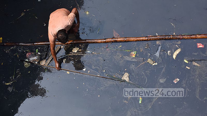 লাইনচ্যুত ওয়াগন থেকে নির্গত তেল মহেশখাল থেকে সংগ্রহ করছেন স্থানীয়রা। ছবি: সুমন বাবু