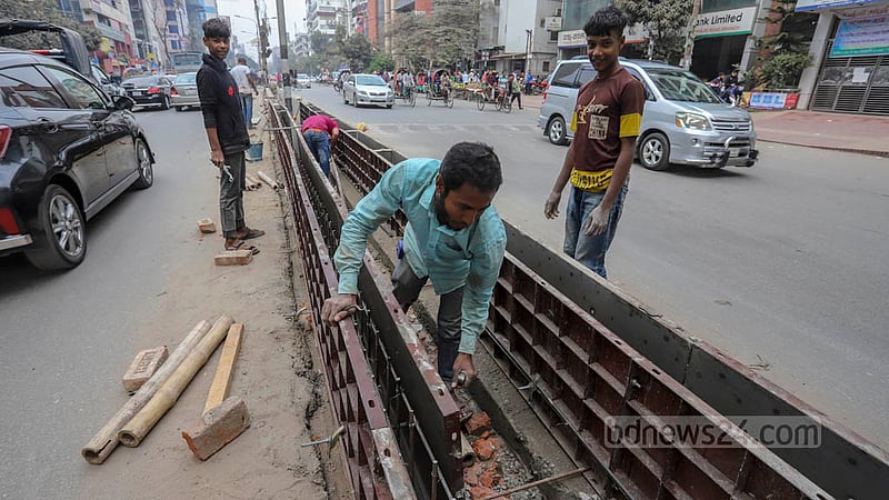 রাজধানীর সাত মসজিদ রোডে ঢাকা দক্ষিণ সিটি করপোরেশন অংশে চলছে নতুন সড়ক বিভাজক তৈরির কাজ। ছবি: আসিফ মাহমুদ অভি