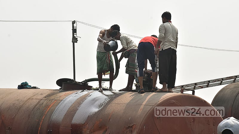 লাইনচ্যুত একটি ওয়াগন থেকে তেল অন্য ওয়াগনে সরিয়ে নিতে দেখা যায় রেলওয়ে কর্তৃপক্ষকে । ছবি: সুমন বাবু