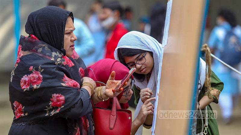 ভিকারুননিসা নূন স্কুল অ্যান্ড কলেজে উচ্চ মাধ্যমিকের ফল প্রকাশের পর নোটিস বোর্ডে শিক্ষার্থীদের সাথে রোল নম্বর &amp;nbsp;খুঁজছেন এক অভিভাবক।&amp;nbsp;ছবি: মাহমুদ জামান অভি
