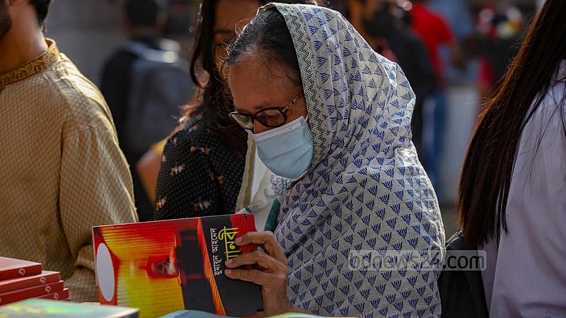 বইমেলায় সোমবার একটি স্টলে বই দেখছেন এক প্রবীণ।&amp;nbsp;ছবি: মাহমুদ জামান অভি