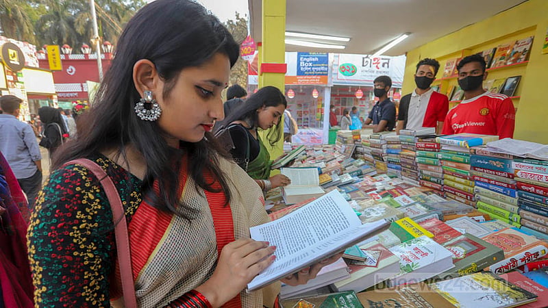 বইমেলায় সোমবার একটি স্টলে বই দেখছেন এক তরুণী। ছবি: আসিফ মাহমুদ অভি
