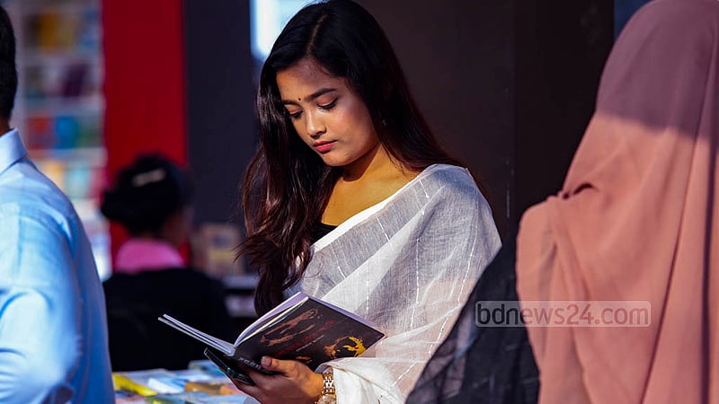 বইমেলায় সোমবার একটি স্টলে বই দেখছেন এক তরুণী।&amp;nbsp;ছবি: মাহমুদ জামান অভি