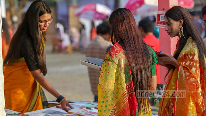 অমর একুশে বইমেলায় সোমবার স্টলের বিক্রেতারাও ছিলেন বাসন্তী সাজে।&amp;nbsp;ছবি: মাহমুদ জামান অভি