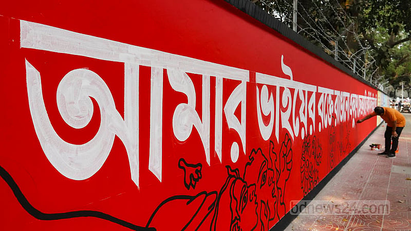 আন্তর্জাতিক মাতৃভাষা দিবস উপলক্ষে কেন্দ্রীয় শহীদ মিনারের পাশে রোববার দেয়াললিখনে ব্যস্ত একজন শিল্পী। ছবি: আসিফ মাহমুদ অভি