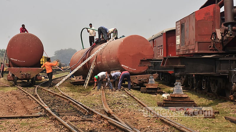 লাইনচ্যুত একটি ওয়াগন থেকে তেল অন্য ওয়াগনে সরিয়ে নিতে দেখা যায় রেলওয়ে কর্তৃপক্ষকে । ছবি: সুমন বাবু