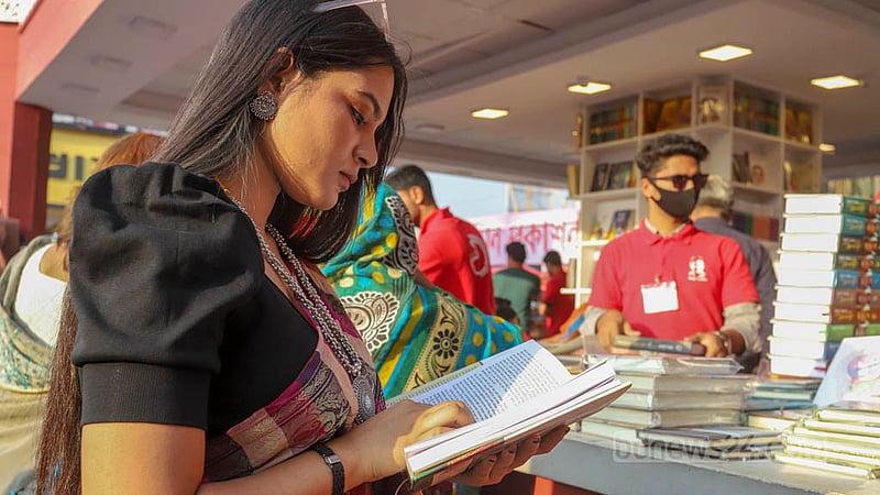 বইমেলায় সোমবার একটি স্টলে বই দেখছেন এক তরুণী। ছবি: আসিফ মাহমুদ অভি