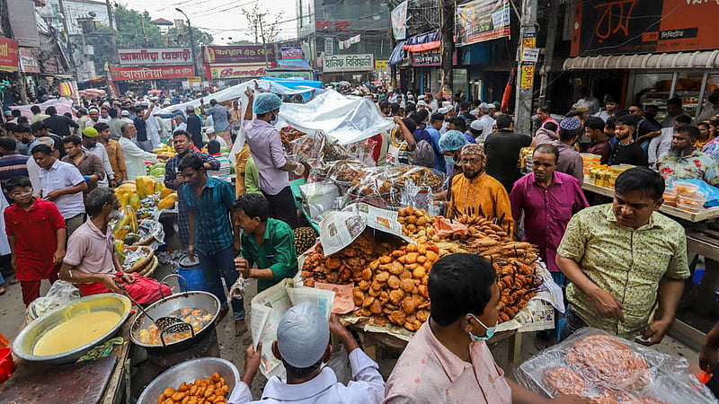রোজার প্রথম দিন পুরান ঢাকার চকবাজারে জমে ওঠে ইফতার কেনাকাটা। এ সময় বৃষ্টি নামলে উপরে পলিথিন দিয়ে বিক্রি করতে দেখা যায়। ছবি: আসিফ মাহমুদ অভি