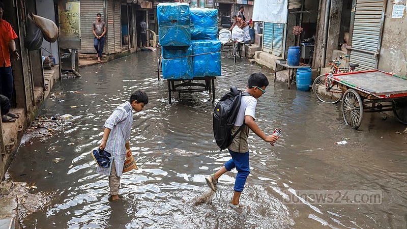 ময়লা পানি মাড়িয়ে চলা দুই শিক্ষার্থীর ছবিটি পুরান ঢাকার মাজেদ সরদার রোডের সিক্কাটুলী এলাকার। ছবি: আসিফ মাহমুদ অভি