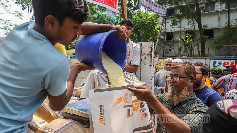 খাদ্য অধিদপ্তরের ওএমএসের ট্রাক থেকে জনপ্রতি পাঁচ কেজি চাল ও পাঁচ কেজি আটা দেওয়া হয়। ছবি: আসিফ মাহমুদ অভি