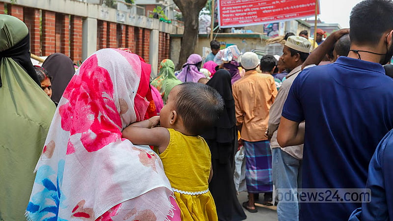দুর্মূল্যের বাজারে ওএমএসের ট্রাক সেল থেকে ৩০ টাকা কেজি দরে চাল আর ২৪ টাকা কেজিতে আটা কিনতে ছোট্ট শিশুকে নিয়ে দাঁড়িয়েছেন এক নারী। ছবি: আসিফ মাহমুদ অভি