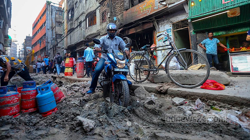পুরান ঢাকার কাজী আলাউদ্দিন সড়কে খানাখোঁদলের মধ্যে মোটরসাইকেল চালিয়ে যাচ্ছনে এক ব্যক্তি।&amp;nbsp;ছবি: মাহমুদ জামান অভি