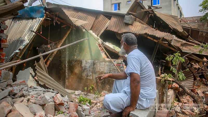 বুড়িগঙ্গা নদীর সীমানা পিলারের ভেতরে থাকা অবৈধ স্থাপনা উচ্ছেদে মঙ্গলাবার অভিযান চালায় বিআইডব্লিউটিএ। কামরাঙ্গীরচরের মাতবর বাজার এলাকার মোহাম্মদ মনিরের স্থাপনাও ভাঙা পড়ে এই অভিযানে, ধ্বংসাবশেষের মাঝে বসে থাকতে দেখা যায় তাকে।&amp;nbsp;ছবি: তাওহীদুজ্জামান তপু