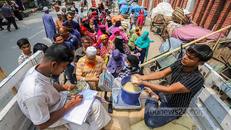 ৩০ টাকা কেজি দরে চাল ও ২৪ টাকা দরে আটা বিক্রি করা হয় ওএমএসের ট্রাক সেলে। ঢাকার আজিমপুরে মঙ্গলবার চাল মাপছেন এক বিক্রয় প্রতিনিধি। ছবি: আসিফ মাহমুদ অভি