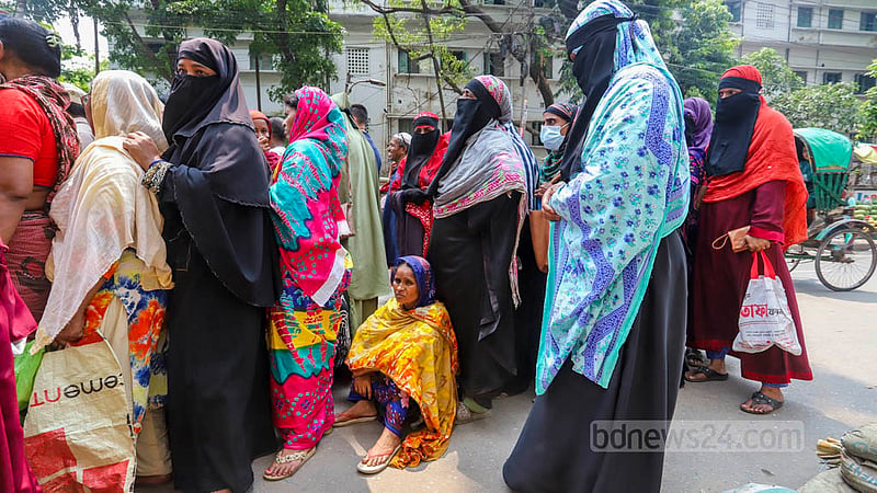 ওএমএসের ট্রাক সেলের সামনে দীর্ঘ সময় দাঁড়িয়ে ক্লান্ত এক নারী সড়কেই বসে পড়েন। ছবি: আসিফ মাহমুদ অভি