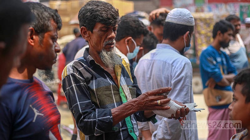 কামরাঙ্গীরচরের সাপ্তাহিক হাটে কবুতর দেখছেন একজন ক্রেতা।&amp;nbsp;ছবি: তাওহীদুজ্জামান তপু