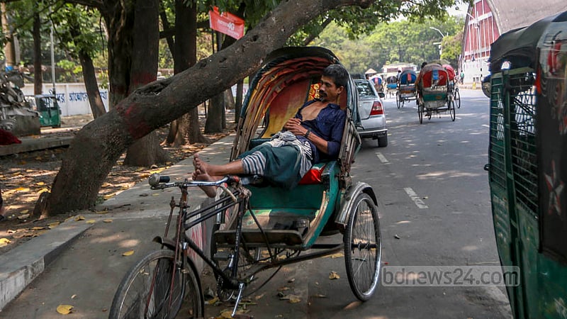 প্রচণ্ড গরমের মধ্যে সোমবার দুপুরে ঢাকা বিশ্ববিদ্যালয়ের টিএসসি এলাকায় গাছের ছায়ায় রিকশা থামিয়ে জিরিয়ে নিচ্ছিলেন চালক।&amp;nbsp;ছবি: তাওহীদুজ্জামান তপু