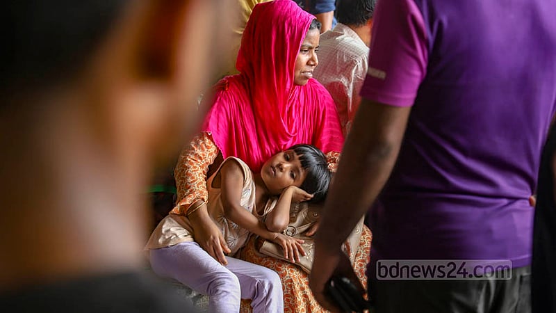 বিমানবন্দর রেলওয়ে স্টেশনে শুক্রবার সকালে গরমের মধ্যে ট্রেনের অপেক্ষায় থেকে ক্লান্ত হয়ে পড়েন এক নারী ও শিশু।&amp;nbsp;ছবি: মাহমুদ জামান অভি