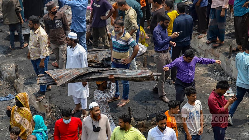বঙ্গবাজারের আগুন নেভার পর পোড়া টিন, পোড়া টাকার সিন্দুকসহ যা পাওয়া যাচ্ছে, তাই কুড়িয়ে নিতে ব্যস্ত একদল মানুষ।&amp;nbsp;ছবি: মাহমুদ জামান অভি