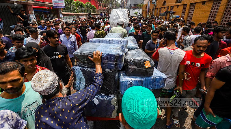 ঢাকার বঙ্গবাজারের আগুন ছড়িয়ে পড়ার আগেই কিছু পণ্য উদ্ধার করতে পেরেছেন এই দোকানি। পরে তা ভ্যানে করে অন্যত্র নিয়ে যান।&amp;nbsp;ছবি: মাহমুদ জামান অভি