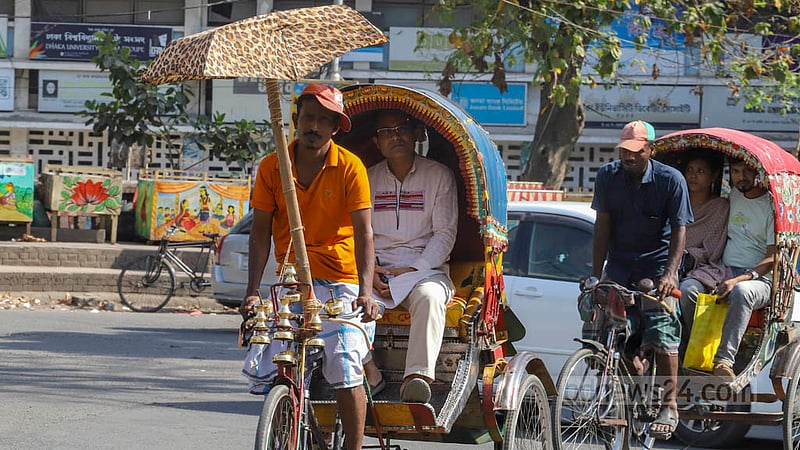 রোদের তীব্রতা থেকে রক্ষা পেতে রিকশার হাতলে বাঁশ দিয়ে ছাতা লাগিয়েছেন এক চালক। ছবি: আসিফ মাহমুদ অভি