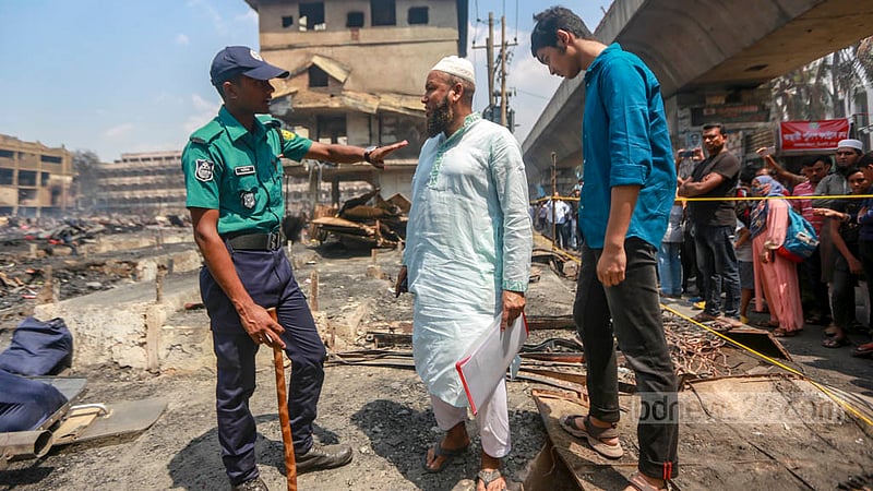 ঢাকার বঙ্গবাজারের ধ্বংসস্তূপের দিকে যেতে চাইলে পুলিশের বাধার মুখে পড়েন এক দোকানি।&amp;nbsp;ছবি: তাওহীদুজ্জামান তপু
