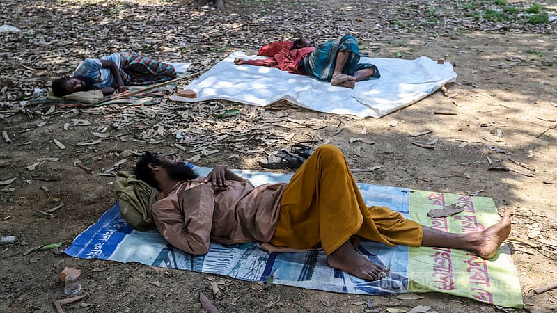 সবুজে ঘেরা সোহরাওয়ার্দী উদ্যানে, ক্লান্ত দুপুরে ছায়া পেয়ে শনিবার শুয়ে থাকতে দেখা যায় ছিন্নমূল মানুষদের।&amp;nbsp;ছবি: আসিফ মাহমুদ অভি