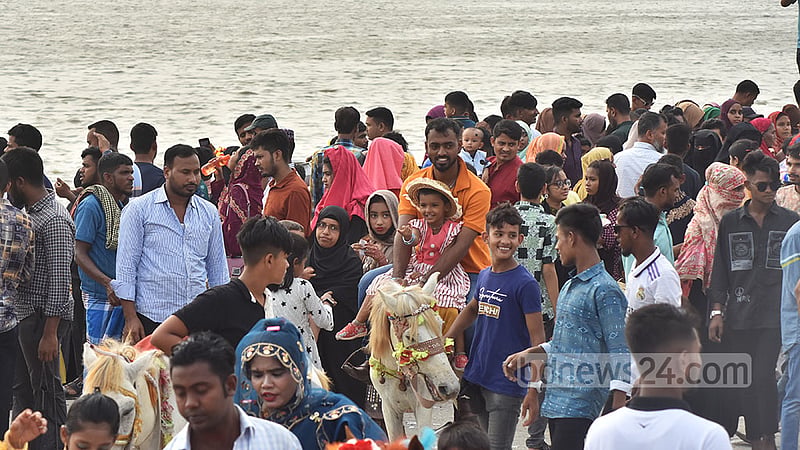 চট্টগ্রামের বিনোদন কেন্দ্র পতেঙ্গা সমুদ্র সৈকতে পরিবারের সদস্যদের সঙ্গে ঘোড়ায় চড়ছে এ শিশু।&amp;nbsp;ছবি: সুমন বাবু