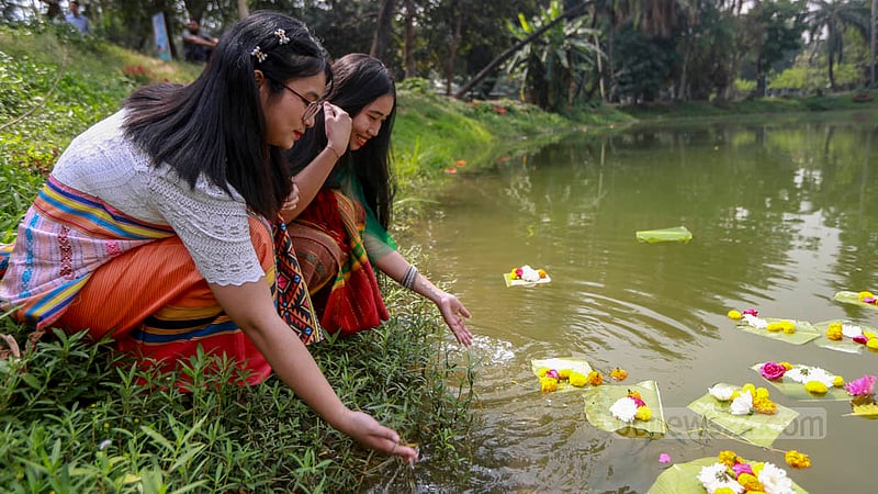 ঢাকার রমনা পার্কে বুধবার বৈসাবি উৎসবে লেকের পানিতে ফুল ভাসান পাহাড়ি নৃ-গোষ্ঠীর এই দুই তরুণী।&amp;nbsp;ছবি: তাওহীদুজ্জামান তপু