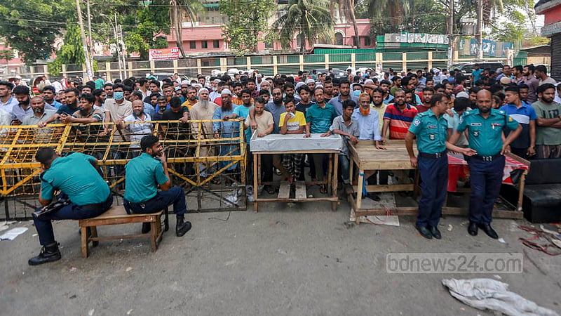 দোকানিরা পুলিশের ব্যারিকেডের সামনে দাঁড়িয়ে দেখছেন দোকানের ধ্বংসস্তূপ।&amp;nbsp;ছবি: তাওহীদুজ্জামান তপু