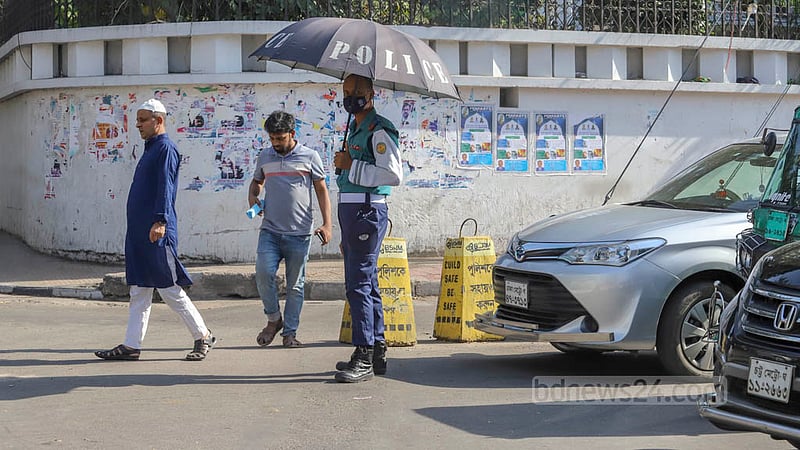 চৈত্রের কাঠফাটা রোদে ছাতা হাতে কাজে এক ট্রাফিক পুলিশ সদস্য। ছবি: আসিফ মাহমুদ অভি