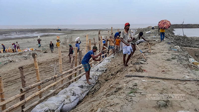 ঘূর্ণিঝড় ‘মোখা’ উপকূলে আঘাত হানার আগে চট্টগ্রাম বেড়িবাঁধ এলাকার আকমল আলী ঘাটের জেলে পাড়া রক্ষায় বাঁধ দেওয়া হচ্ছে।