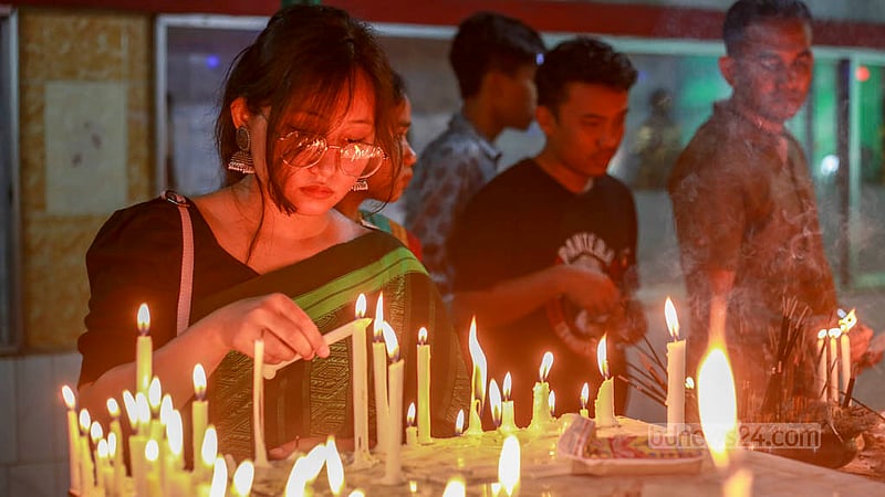 বুদ্ধ পূর্ণিমায় সবুজবাগে ধর্মরাজিক বৌদ্ধ মহাবিহারে বৃহস্পতিবার মোমবাতি জালিয়ে প্রার্থনারত এক পুণ্যার্থী।&amp;nbsp;ছবি: তাওহীদুজ্জামান তপু