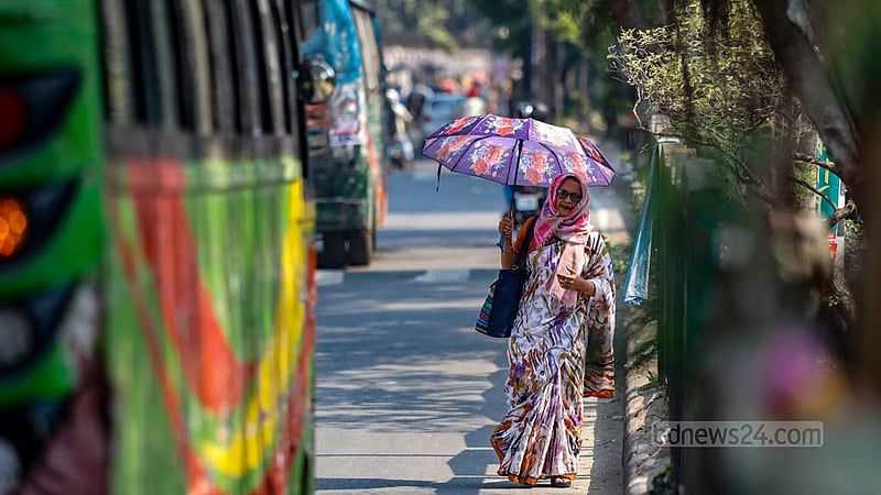 তীব্র রোদে বুধবার নীলক্ষেত এলাকায় ছাতা হতে এক নারী।&amp;nbsp;ছবি: মাহমুদ জামান অভি