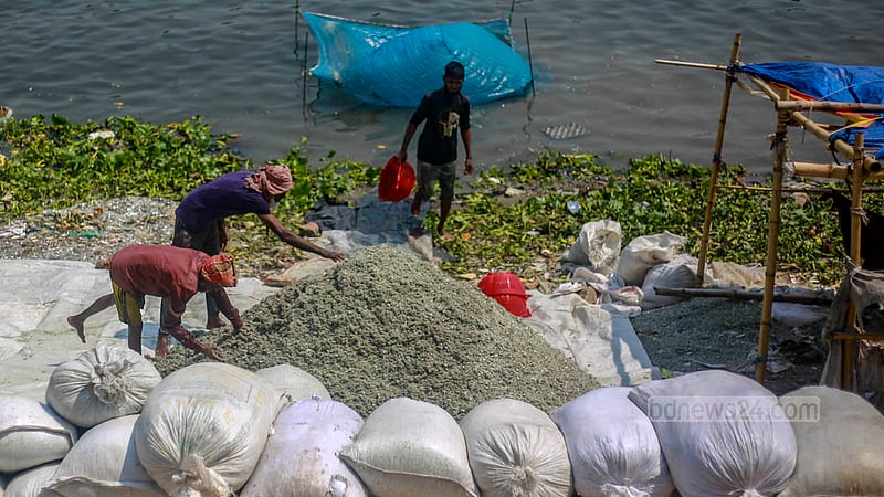 ঢাকার বুড়িগঙ্গা নদীর তীরে বিভিন্ন ধরনের প্লাস্টিকের কুচি শুকানোর জন্য মেলে দিচ্ছেন শ্রমিকরা।&amp;nbsp;ছবি: তাওহীদুজ্জামান তপু