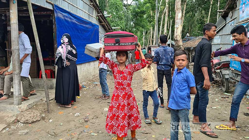 কক্সবাজারের উপকূলীয় এলাকায় ঘূর্ণিঝড় ‘মোখা’র প্রভাব শুরুর আগে শনিবার মালপত্র নিয়ে আশ্রয়কেন্দ্রের উদ্দেশে এক শিশু।