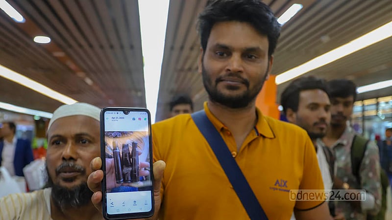 ঢাকায় ফেরা এক বাংলাদেশি নিজের মোবাইলে তোলা সংঘাতময় সুদানের ছবি দেখাচ্ছেন। ছবি: আসিফ মাহমুদ অভি
