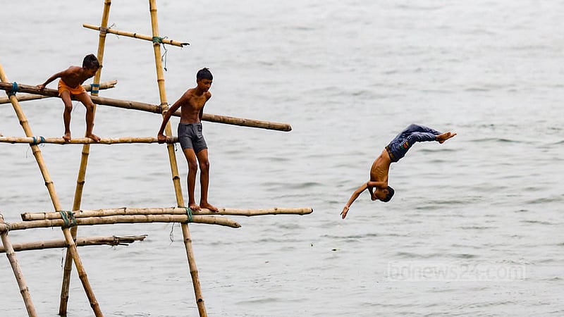 ঢাকার শ্যামপুরের মুন্সিখোলা অংশের বুড়িগঙ্গা নদীর পানিতে ঝাপ দিচ্ছে শিশু-কিশোররা।&amp;nbsp;ছবি: মাহমুদ জামান অভি